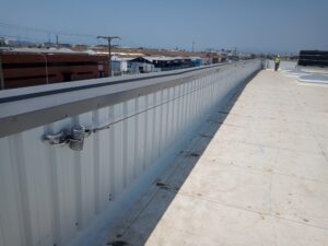 LINEA DE VIDA HOMOLOGADA CONFORME UNE 795 C, PARA PETO DE NAVE INDUSTRIAL TODOS COMPONENTES EN ACERO INOXIDABLE , CON FIJACIÓN A ELEMENTOS ESTRUCTURALES , PROTEGE DE LAS CAIDAS POR LOS BORDES DE LA NAVE, EN ZARAGOZA
