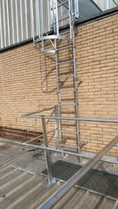 ESCALA DE ACCESO HOMOLOGADA CONFORME UNE 14122-4 , DE ALUMINIO PARA EXTERIORES CON JAULA O PROTECCIÓN DORSAL, PARA FACHADA DE POLIDEPORTIVO CONECTADA A PASARELA DE CUBIERTA